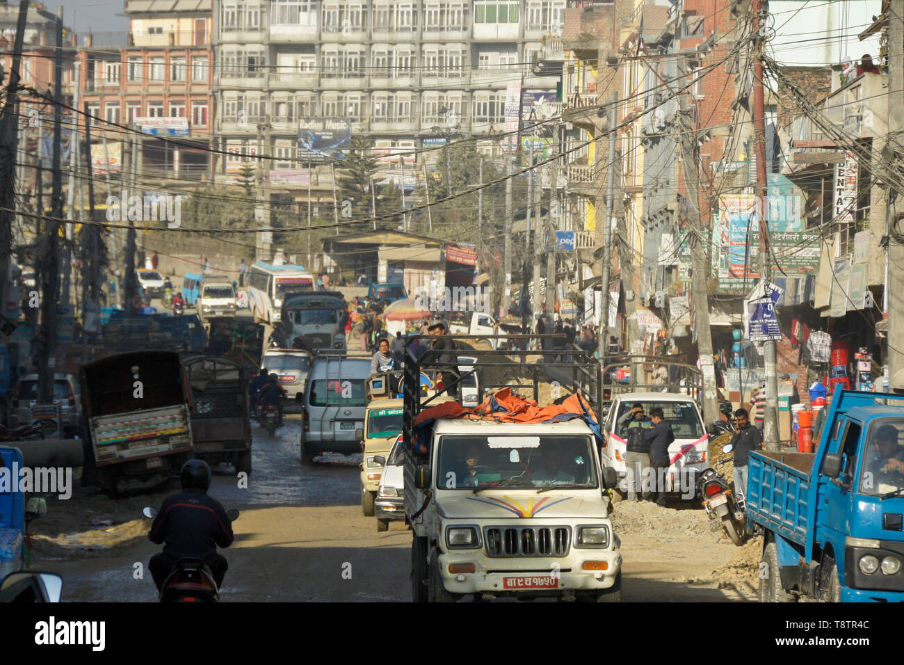 A tangle of vehicles and electrical wires on a crowded street under construction in Kathmandu, Nepal Stock Photo
