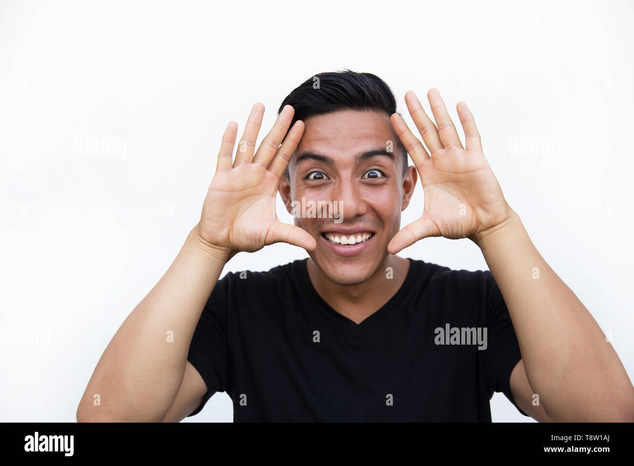 Latin hispanic man shocked with surprised face and making frame with hands over isolated background. Stock Photo