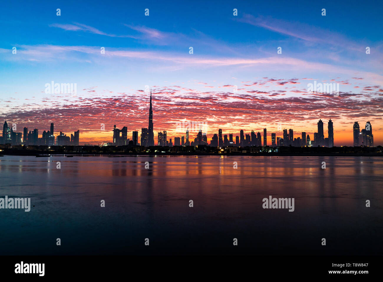 Morning or sunrise, dawn in Dubai. Beautiful colored cloudy sky over downtown Dubai. Glow over skyscraper. Stock Photo