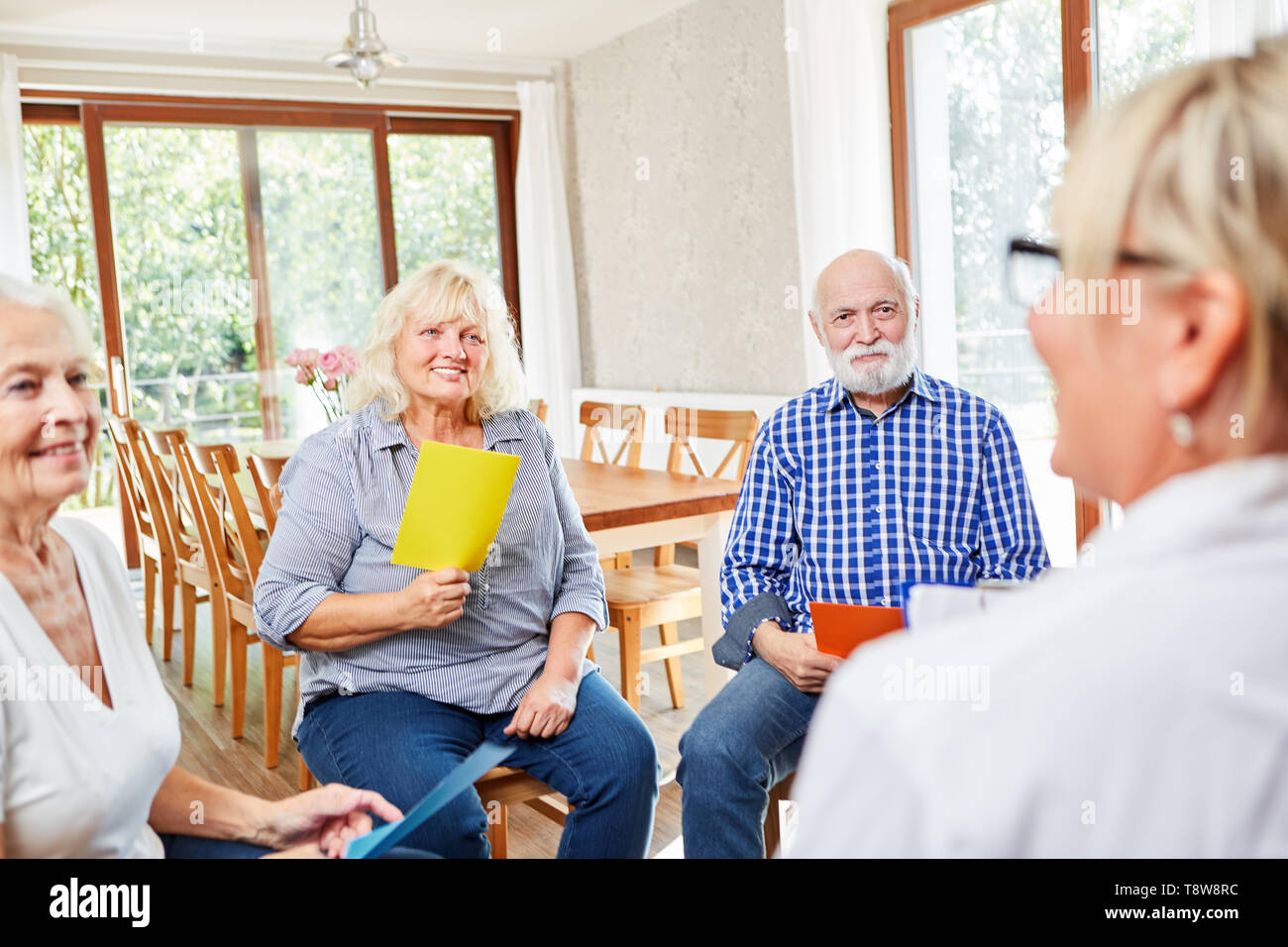 Group of seniors with therapist in a psychotherapy session at retirement home Stock Photo