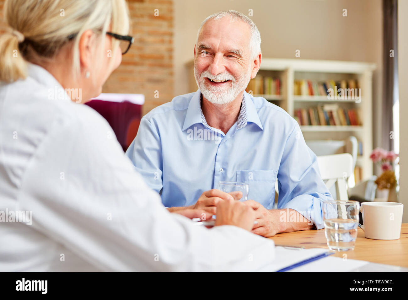Happy senior as a patient in conversation with a female doctor during ...