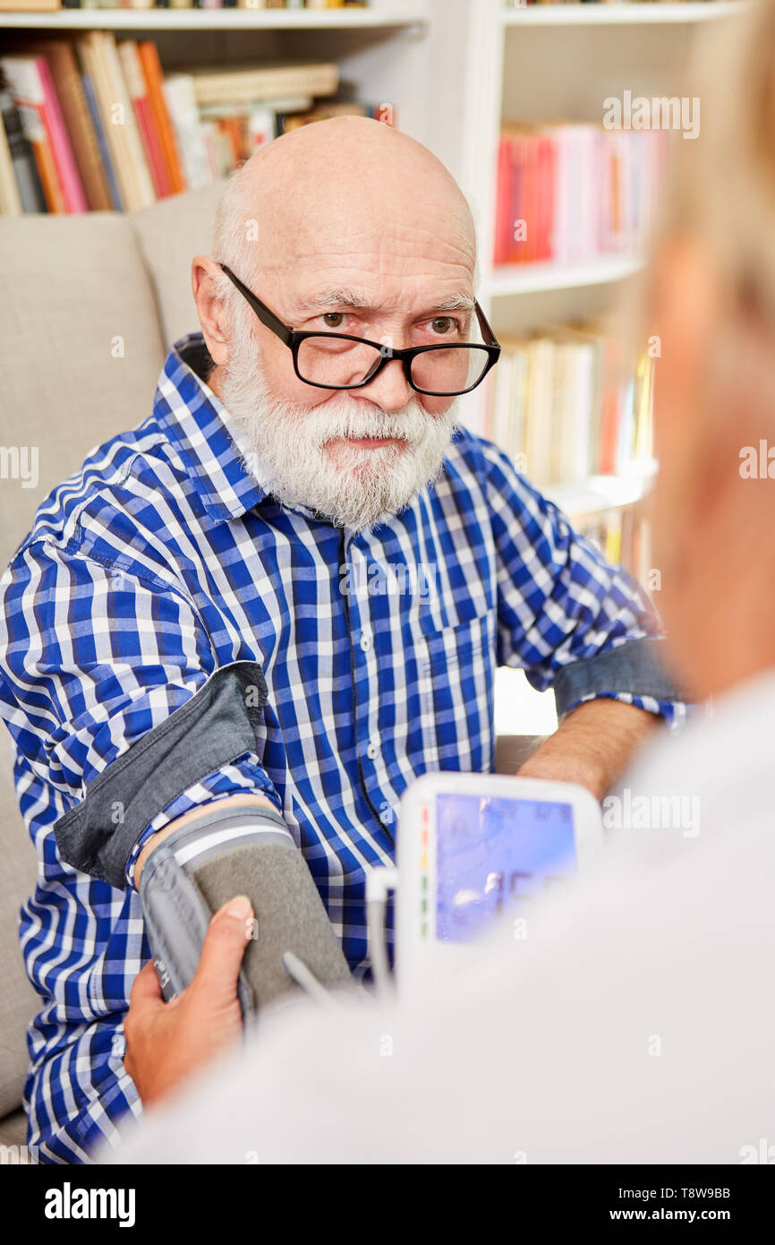 Blood pressure measurement in a senior with dementia or Alzheimer's at nursing home Stock Photo