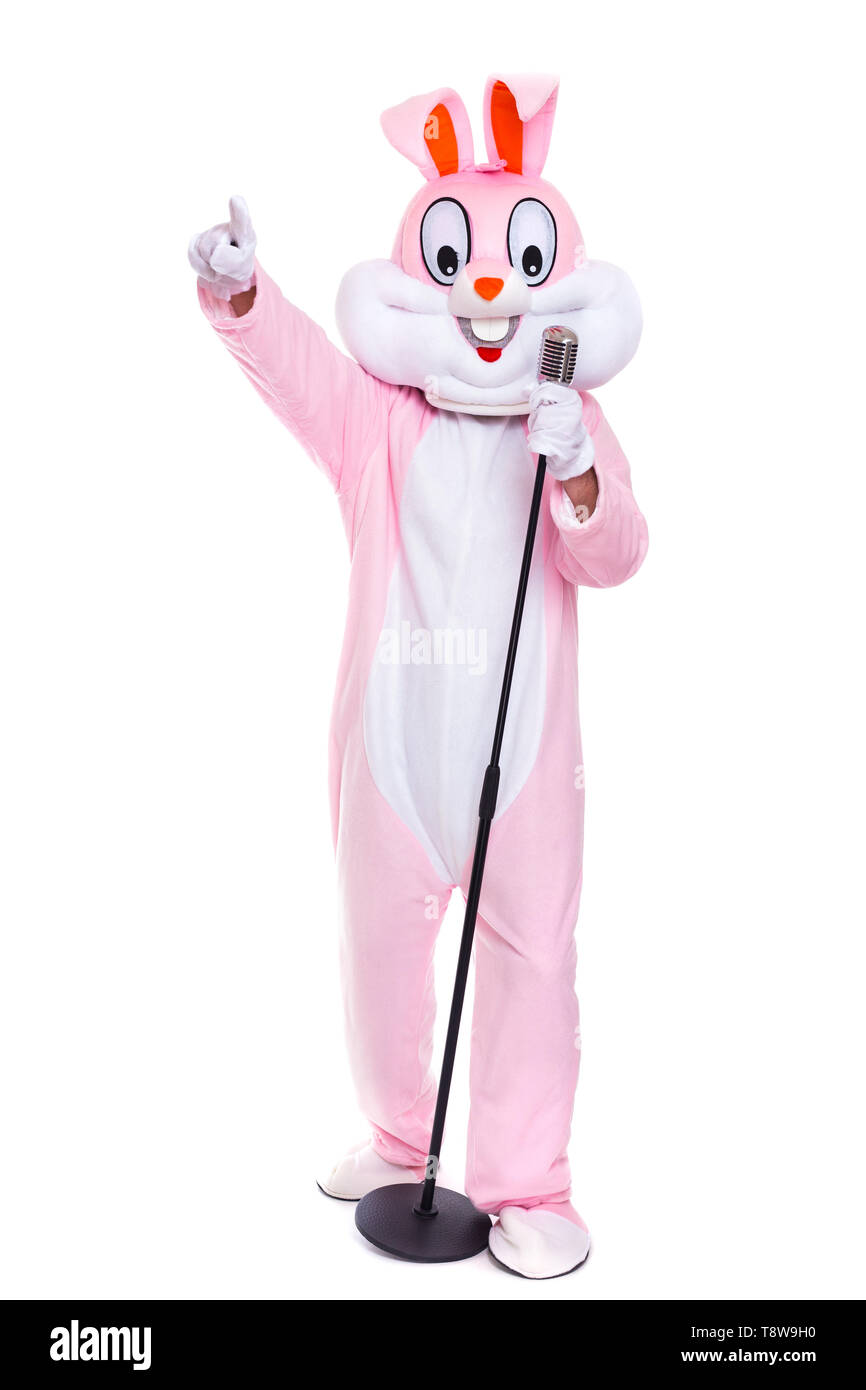 Funny crazy singer sings in Elvis microphone. Easter bunny have fun with retro microphone on white background Stock Photo