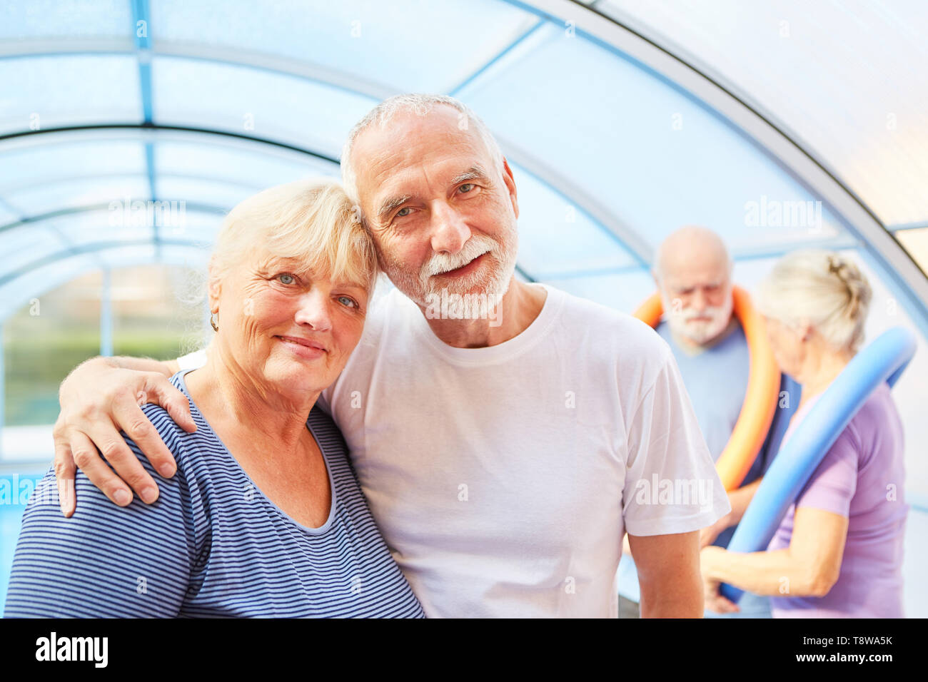 Amorous senior couple in a swimming pool after aquagym Stock Photo
