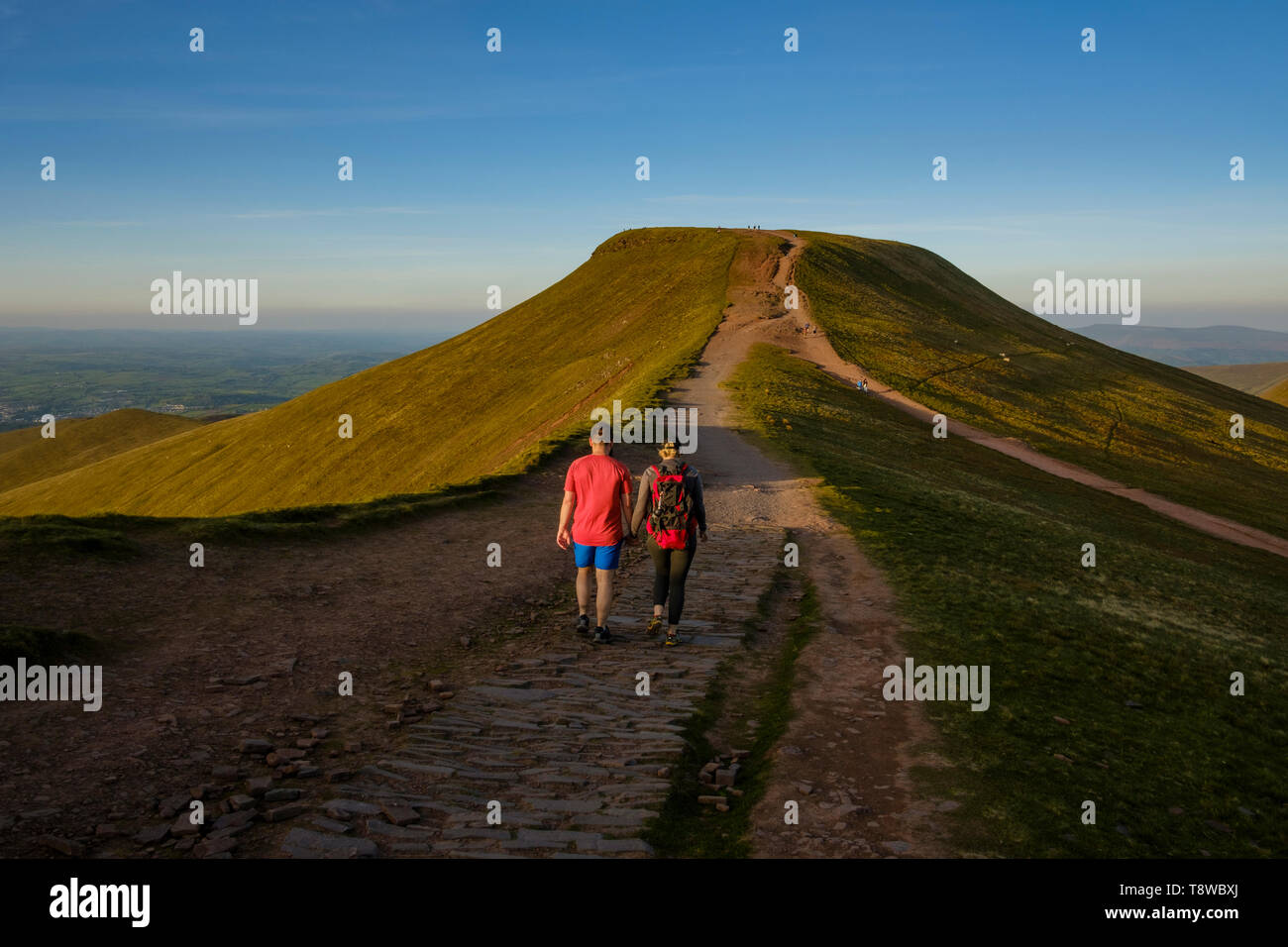 A couple walking towards Pen y Fan Mountain to watch the sun set
