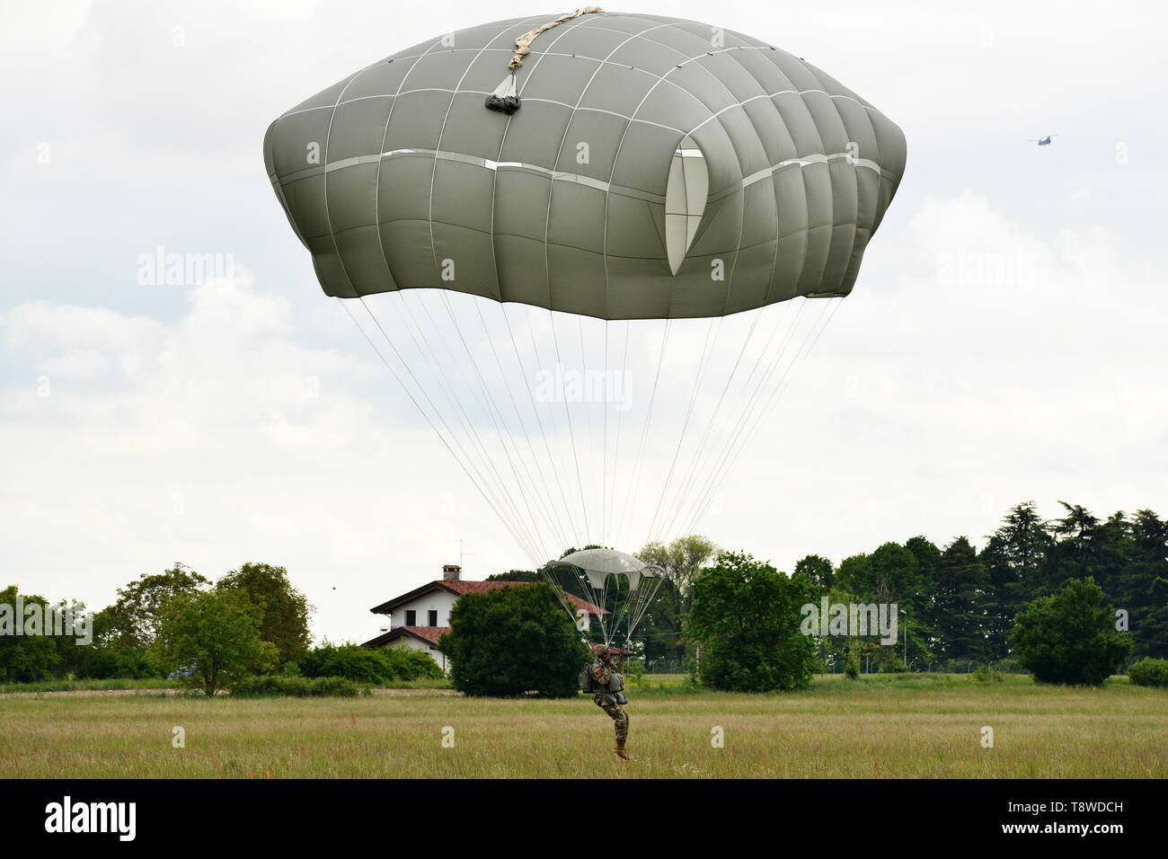 U.S. Army Paratroopers assigned to 54th Brigade Engineer Battalion, 173rd Airborne Brigade, descends onto Juliet Drop Zone, Pordenone, Italy after exiting 12th Combat Aviation Brigade CH-47 Chinook helicopter, during airborne operation, May 9, 2019. The 173rd Airborne Brigade is the U.S. Army's Contingency Response Force in Europe, capable of projecting ready forces anywhere in the U.S. European, Africa or Central Commands' areas of responsibility. (U.S. Army's Photos by Paolo Bovo) Stock Photo