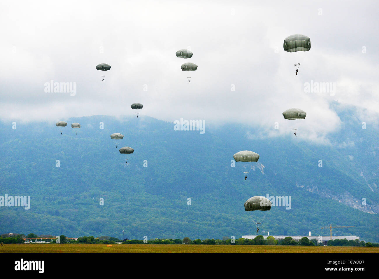 U.S. Army Paratroopers assigned to 54th Brigade Engineer Battalion, 173rd Airborne Brigade, descends onto Juliet Drop Zone, Pordenone, Italy after exiting 12th Combat Aviation Brigade CH-47 Chinook helicopter, during airborne operation, May 9, 2019. The 173rd Airborne Brigade is the U.S. Army's Contingency Response Force in Europe, capable of projecting ready forces anywhere in the U.S. European, Africa or Central Commands' areas of responsibility. (U.S. Army's Photos by Paolo Bovo) Stock Photo