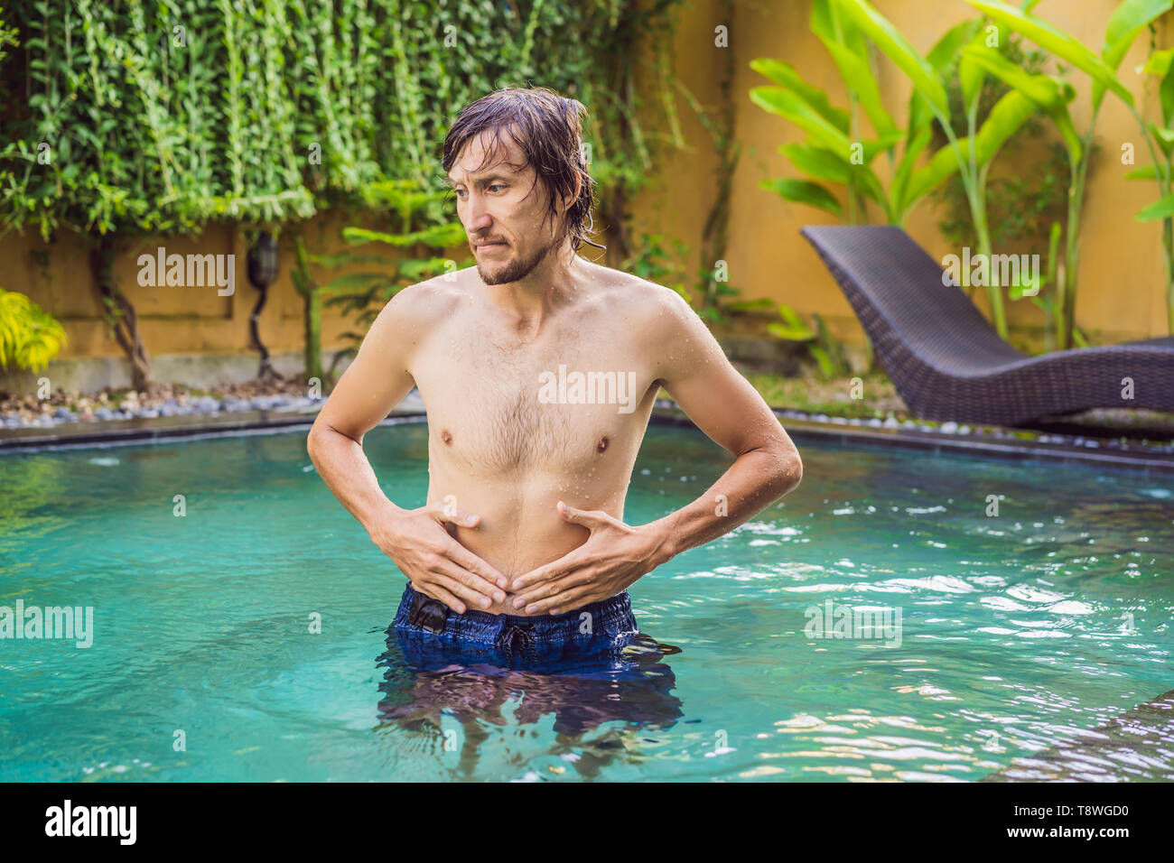 The man's stomach hurts after the pool Stock Photo Alamy