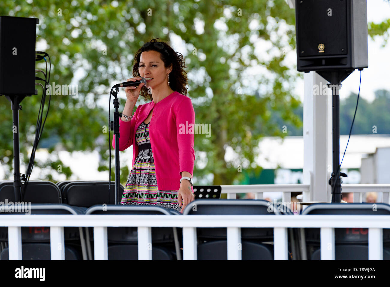 Live music performed on bandstand stage by female performer or singer (soloist) singing into microphone - Great Yorkshire Show, Harrogate, England, UK Stock Photo