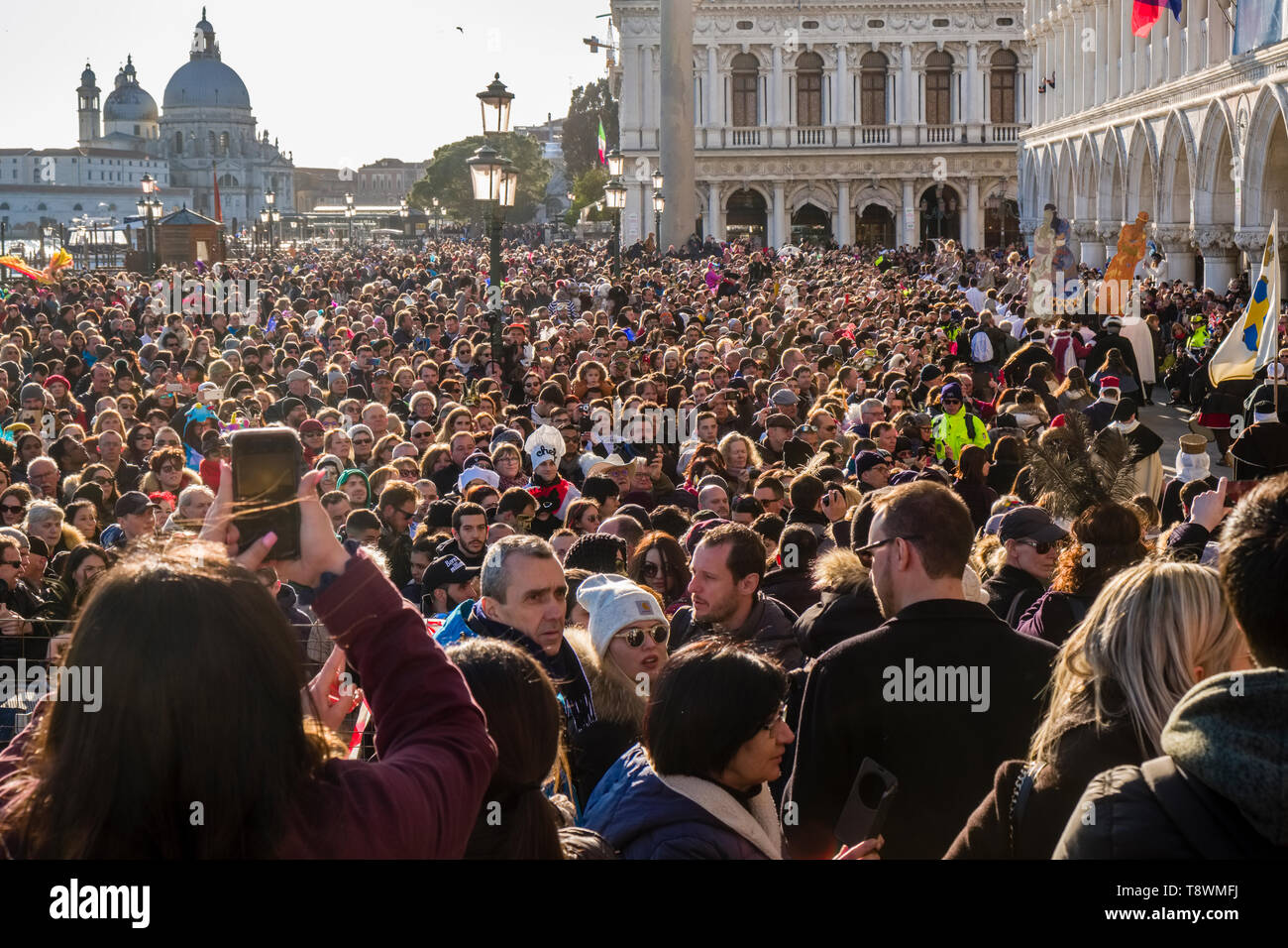 Thousands of people are gathering along the Grand Canal, Canal Grande to celebrate the Venetian Carnival, the Basilica of Saint Mary of Health, Basili Stock Photo