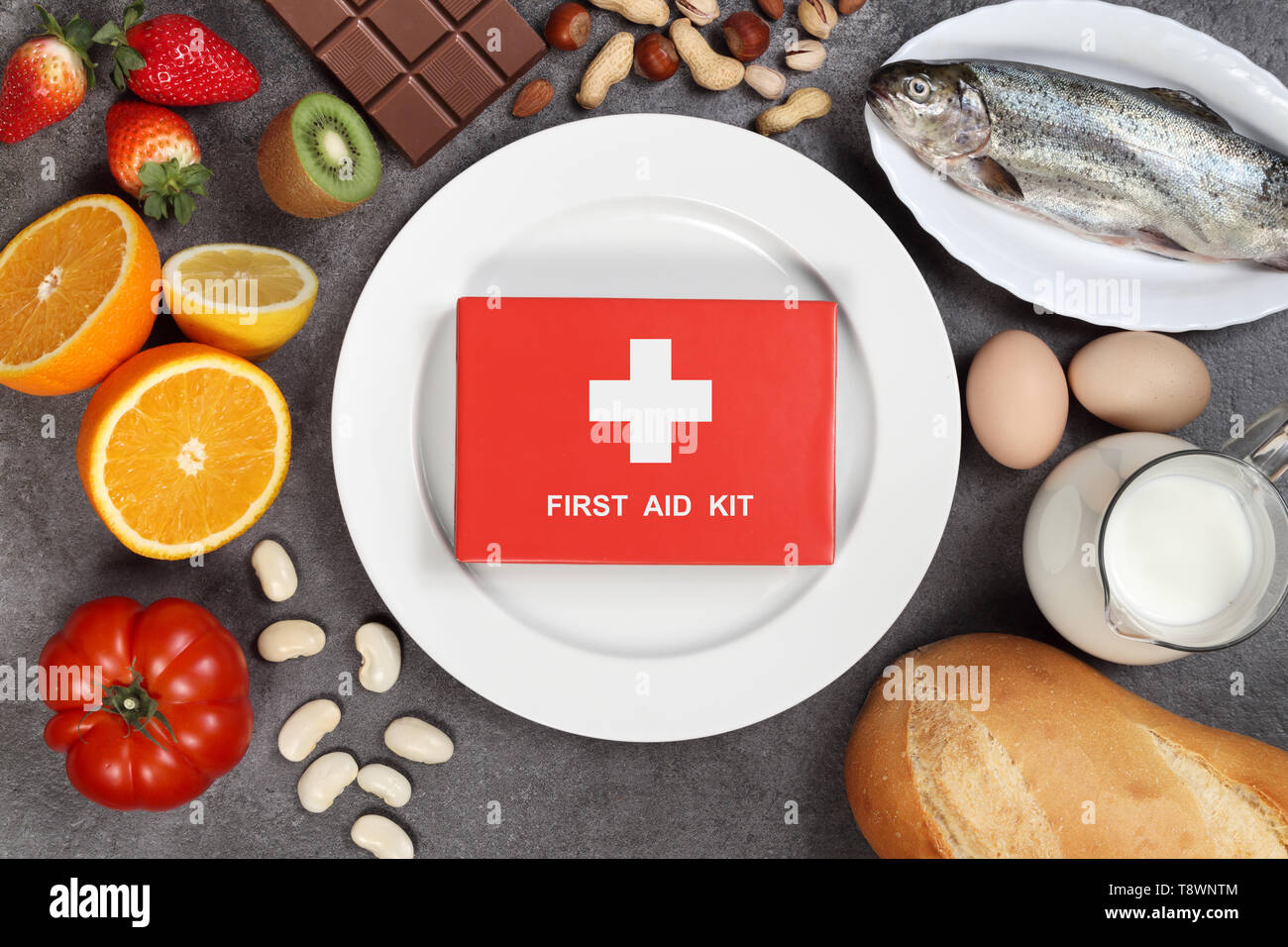 Allergy food concept. Foods, fruits, vegetables, empty plate and first aid kit on grey