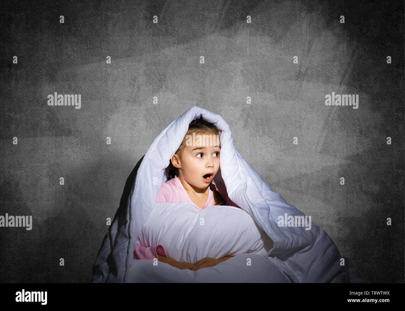 Surprised child hiding under blanket Stock Photo Alamy
