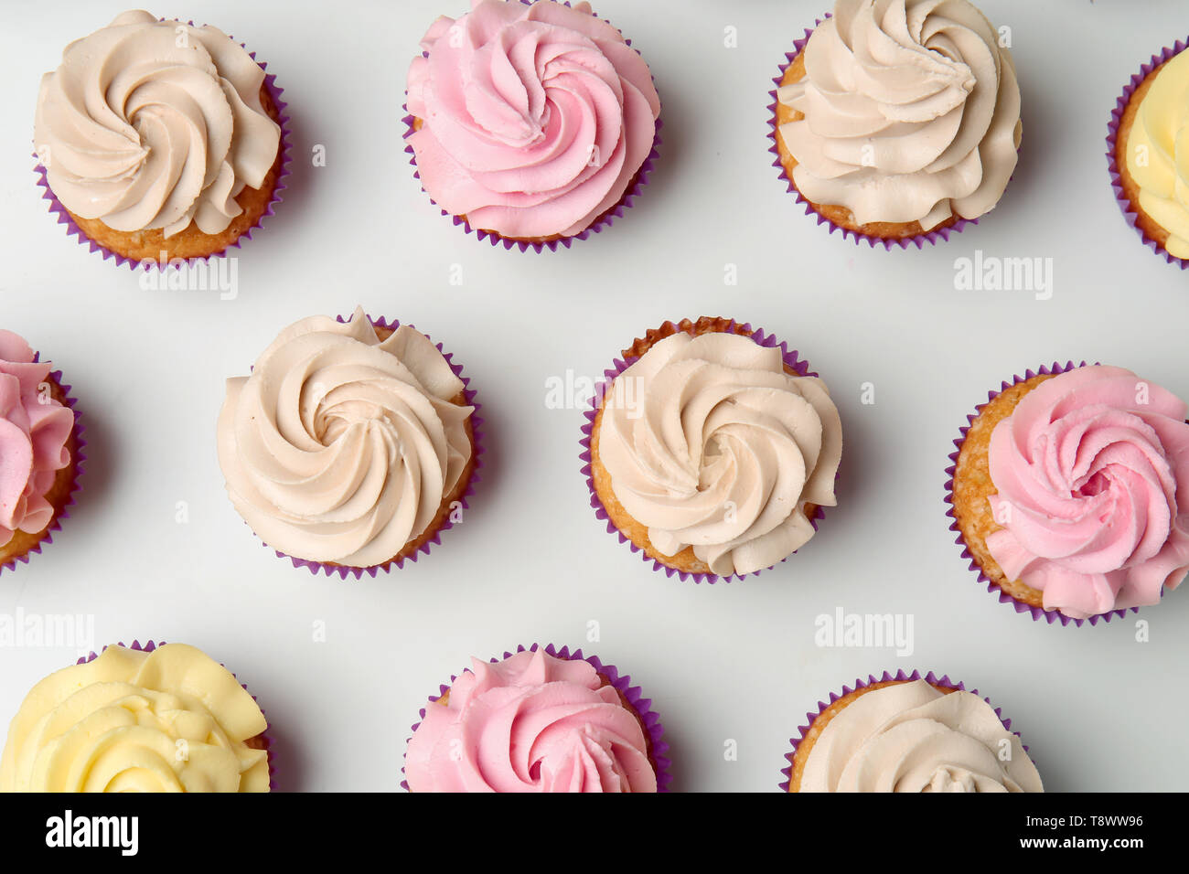 Delicious cupcakes on white background, flat lay Stock Photo