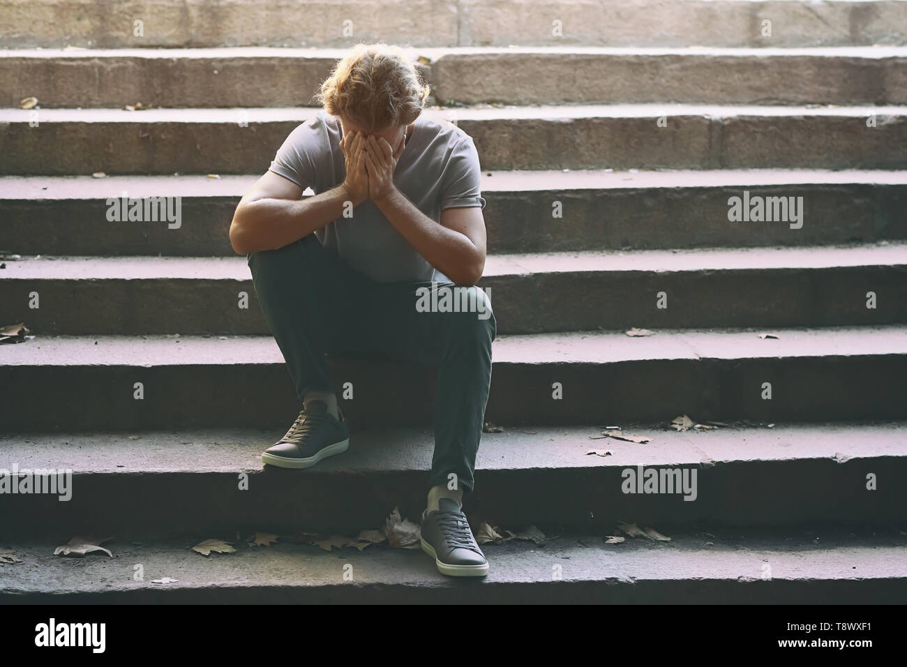 Lonely man sitting on stairs hi-res stock photography and images - Alamy