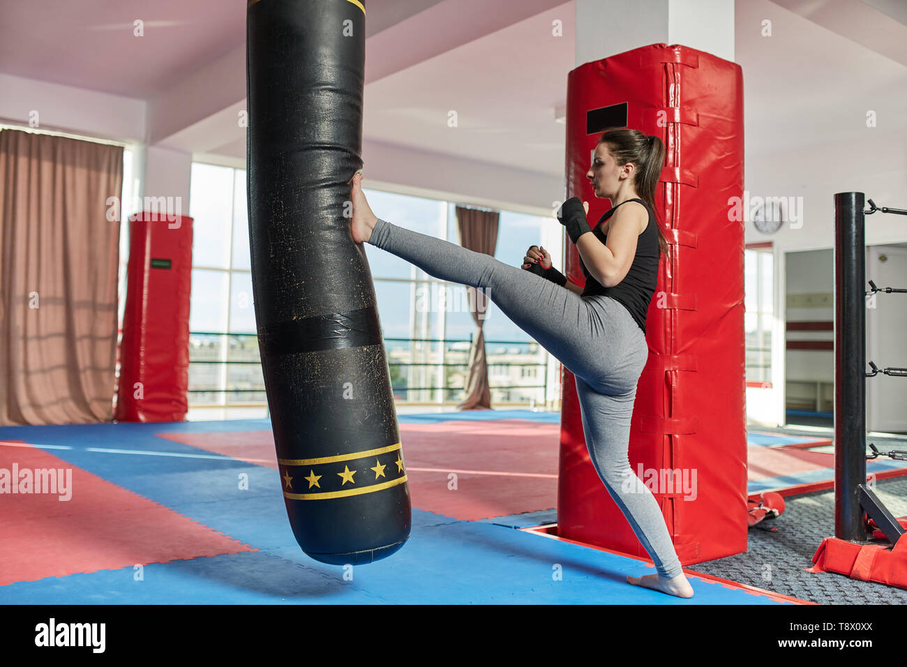 Muay thai female fighter training with the heavy bag Stock Photo - Alamy