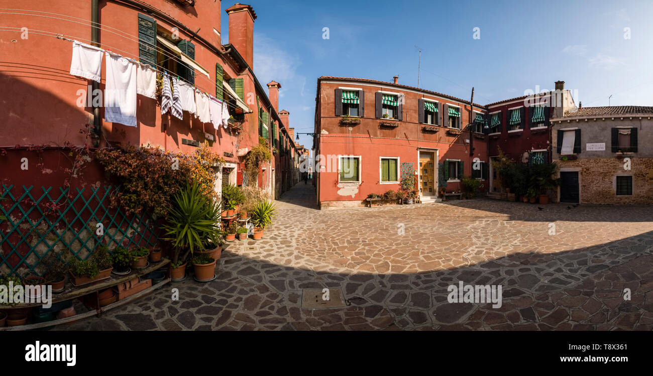 Panoramic view to terracotta color painted houses on the island Giudecca, laundry is put up on washing lines Stock Photo