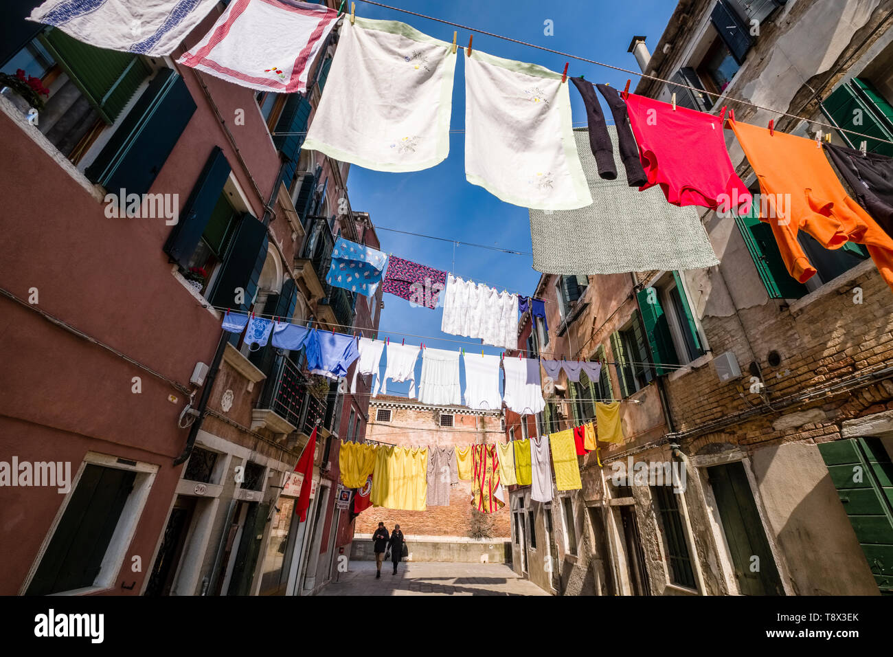Narrow street leading through the ailing brick houses of the so-called 'Floating city', laundry is put up on washing lines Stock Photo