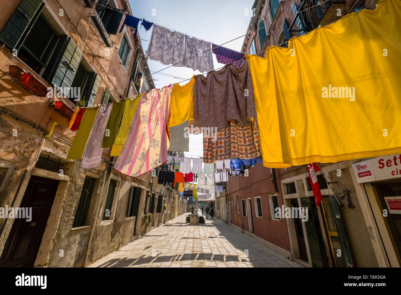 Narrow street leading through the ailing brick houses of the so-called 'Floating city', laundry is put up on washing lines Stock Photo
