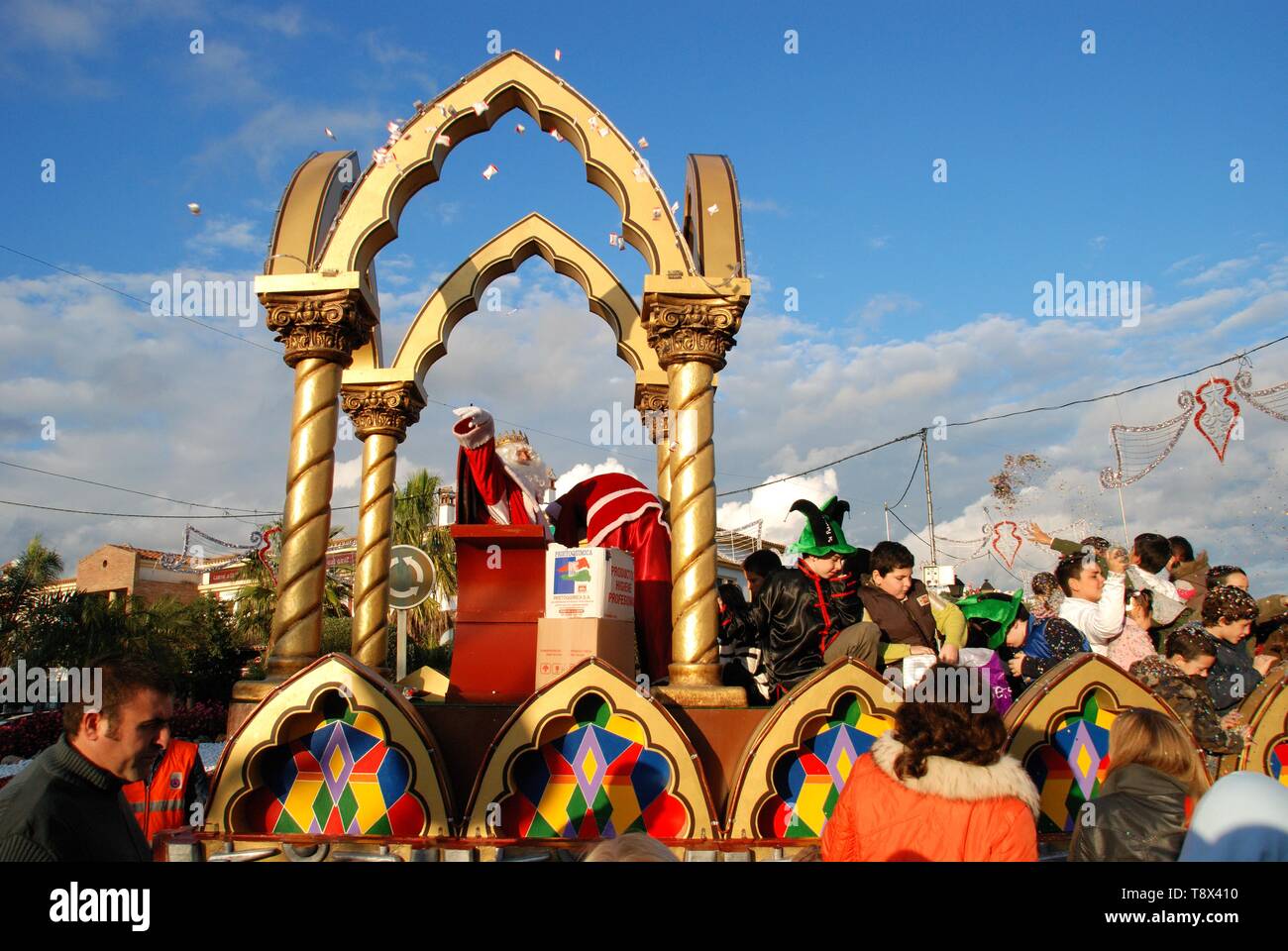 Three Kings Parade with Melchor sitting in his carriage throwing sweets to the public, La Cala de Mijas, Spain. Stock Photo