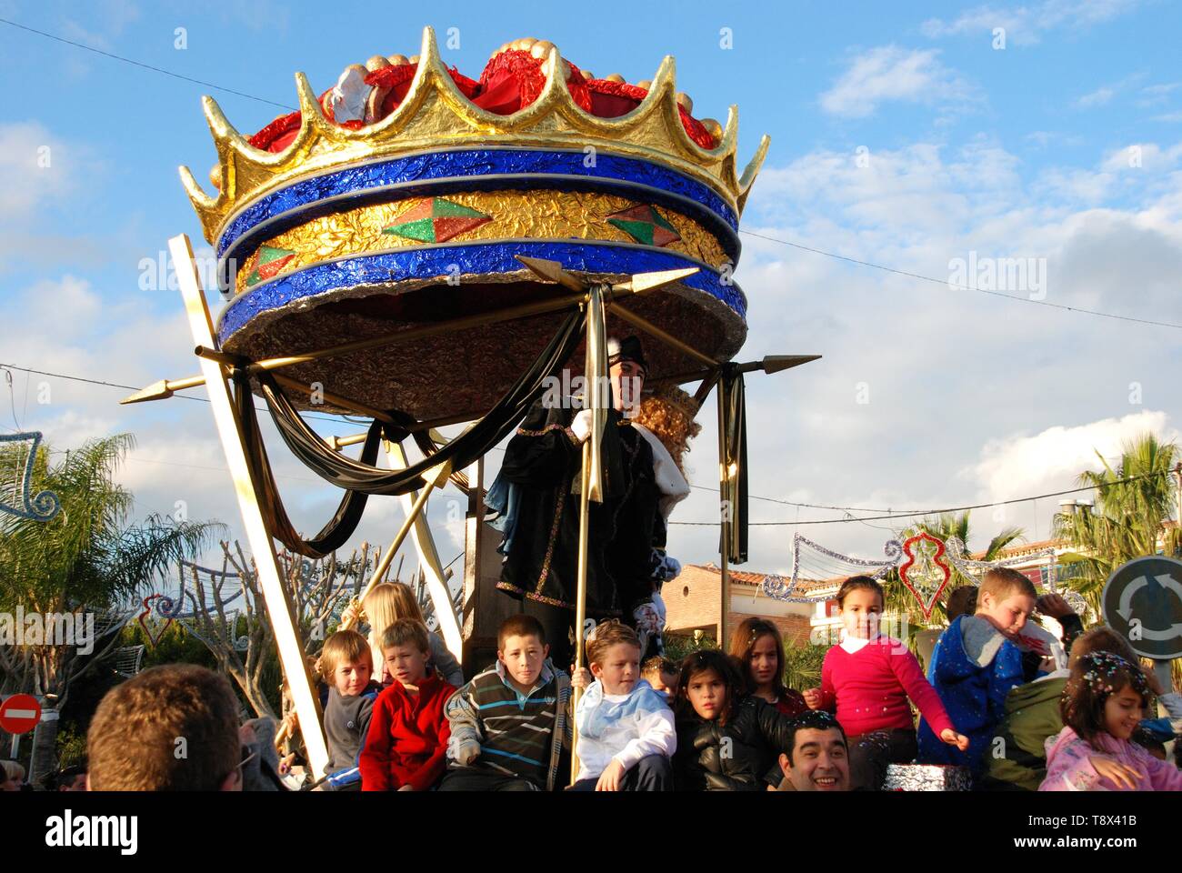 Three Kings Parade with Gaspar standing in his carriage and children sitting on the float, La Cala de Mijas, Spain. Stock Photo