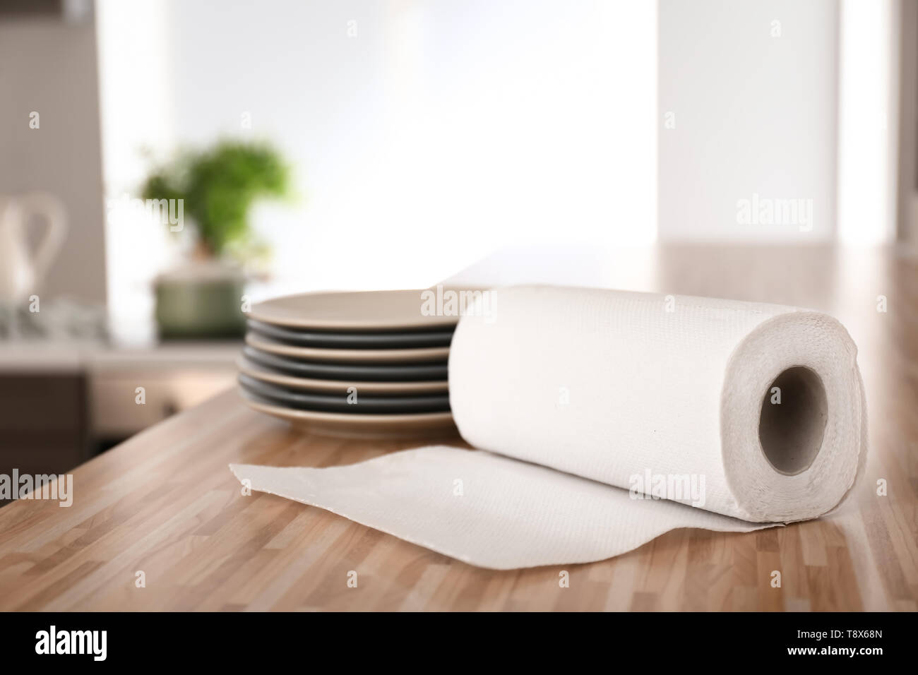 Roll of paper towels with plates on kitchen table Stock Photo Alamy
