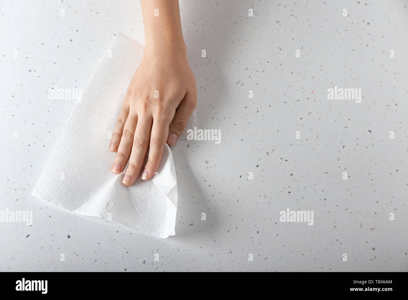 Woman wiping light table with paper towel Stock Photo Alamy