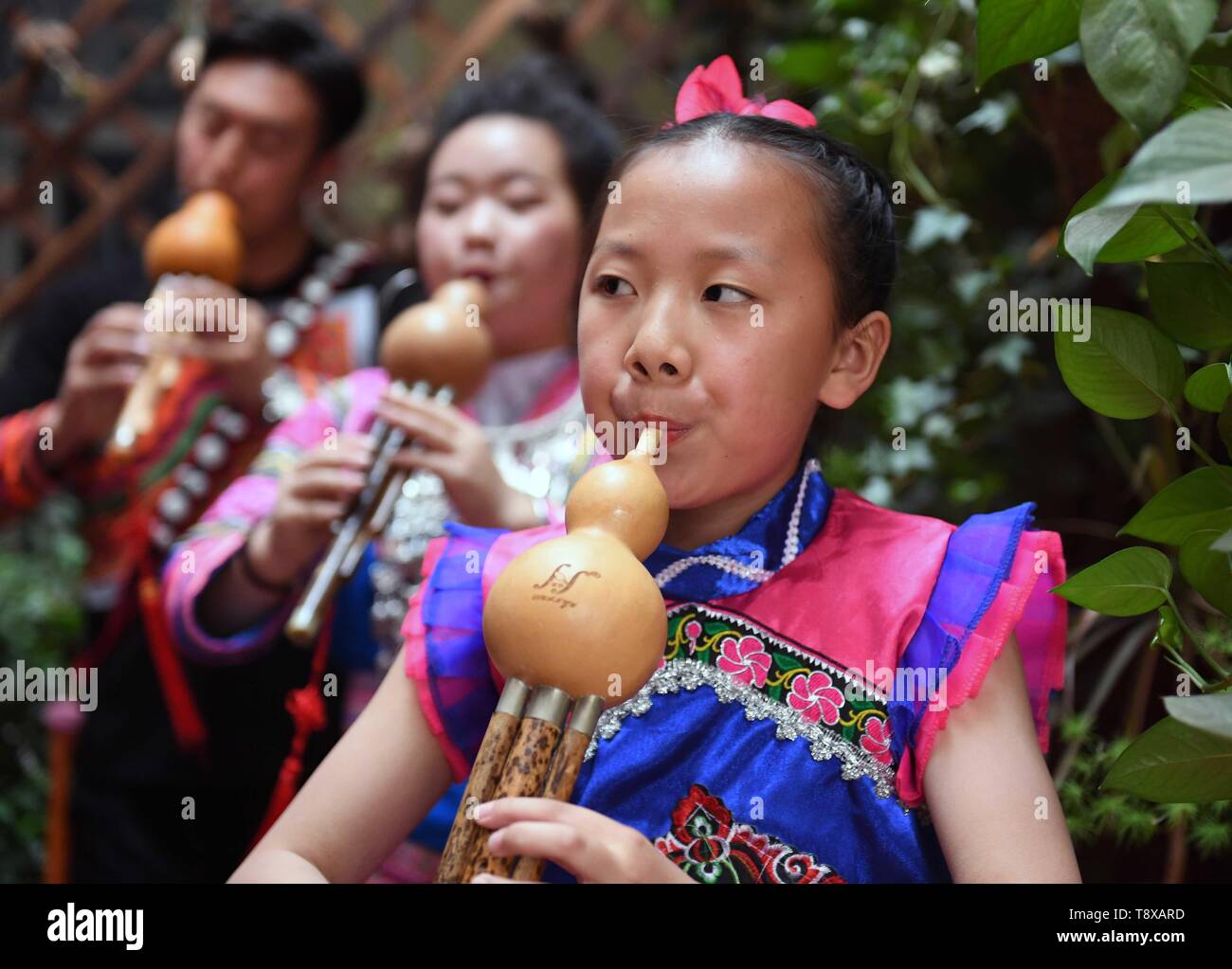 (190515) -- QUJING, May 15, 2019 (Xinhua) -- Students play the Hulusi at an art school at Qujing, southwest China's Yunnan Province, May 11, 2019. Hulusi is a free-reed wind instrument from China. It is made of a gourd with three bamboo pipes inserted into the bottom end of the gourd wind chest. The bamboo pipes consist of one main pipe which has finger holes for making different tones and two drone pipes which can play chord. It is mainly used by minority ethnic groups in Yunnan province and it has a clarinet-like sound. (Xinhua/Yang Zongyou) Stock Photo