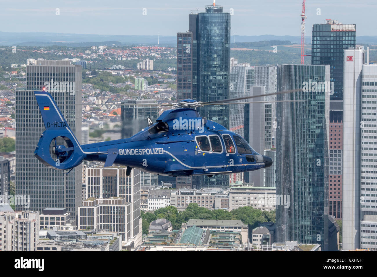 15 May 2019, Hessen, Frankfurt/Main: A Eurocopter EC 155 helicopter of the German Federal Police flies over Frankfurt's bank skyline. The helicopters are ready for action within a very short time and can be used to prosecute perpetrators on the ground, to relocate special units or to monitor railway lines and airports. Photo: Boris Roessler/dpa Stock Photo