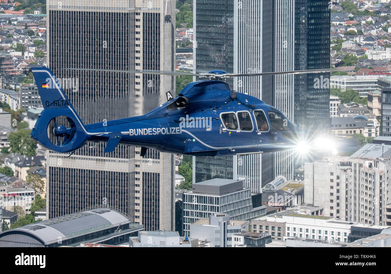 15 May 2019, Hessen, Frankfurt/Main: A Eurocopter EC 155 helicopter of the German Federal Police flies over Frankfurt's bank skyline. The helicopters are ready for action within a very short time and can be used to prosecute perpetrators on the ground, to relocate special units or to monitor railway lines and airports. Photo: Boris Roessler/dpa Stock Photo