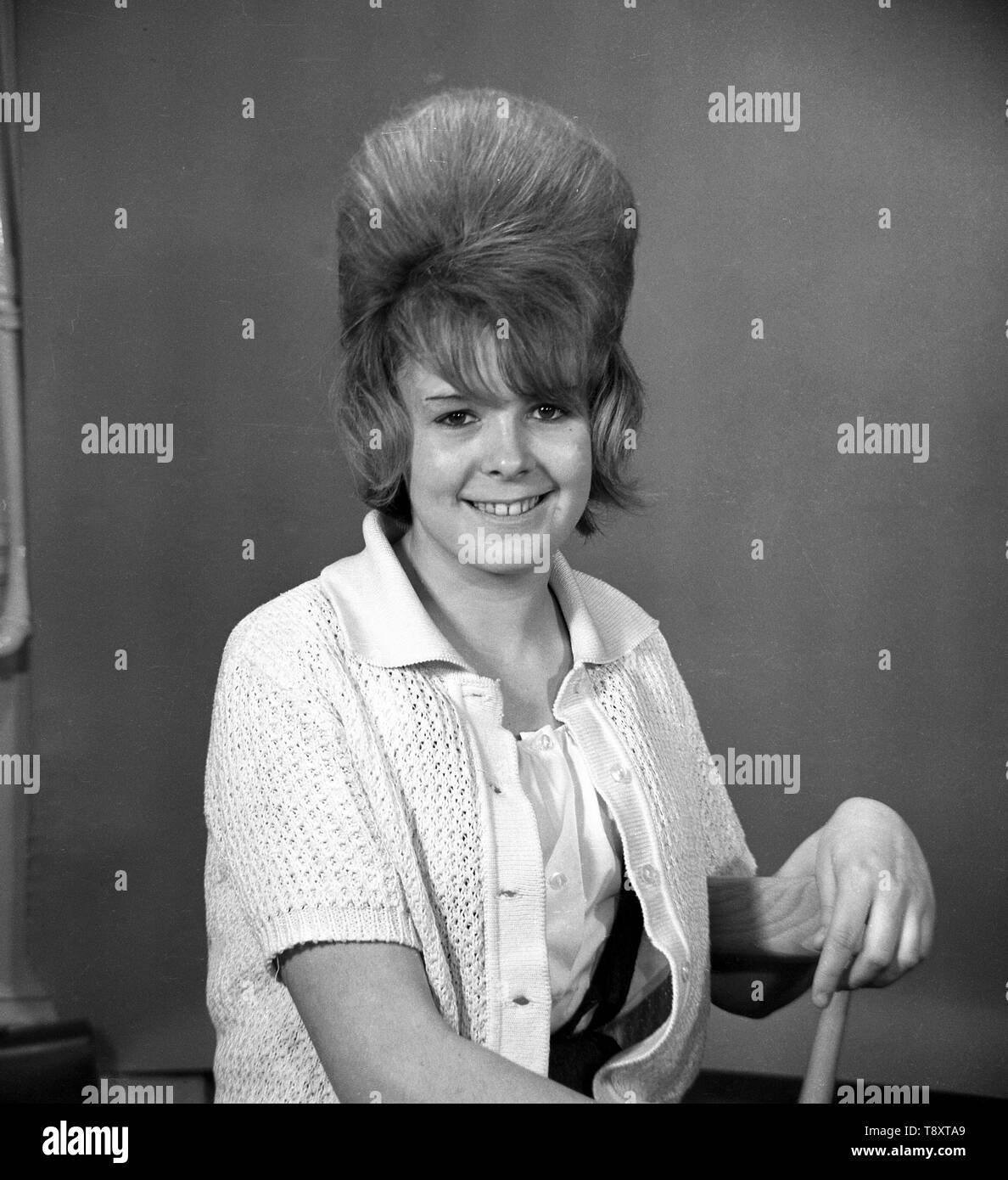 Young woman in a knitted cardigan poses with bouffant hairstyle, UK c1962. Photo by Tony Henshaw Stock Photo