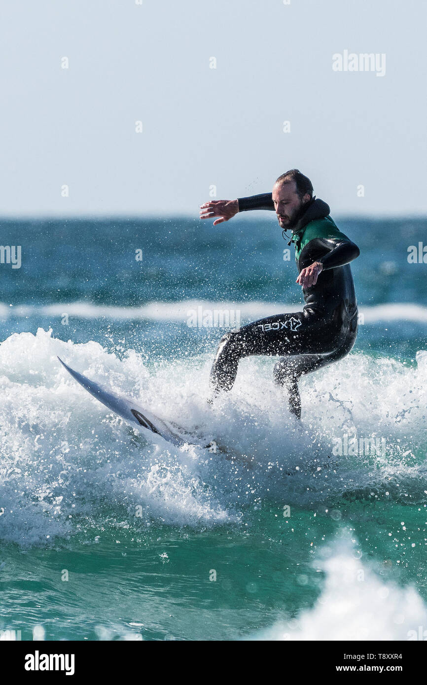 Spectacular surfing action as a surfer wearing an Xcel wetsuit rides a