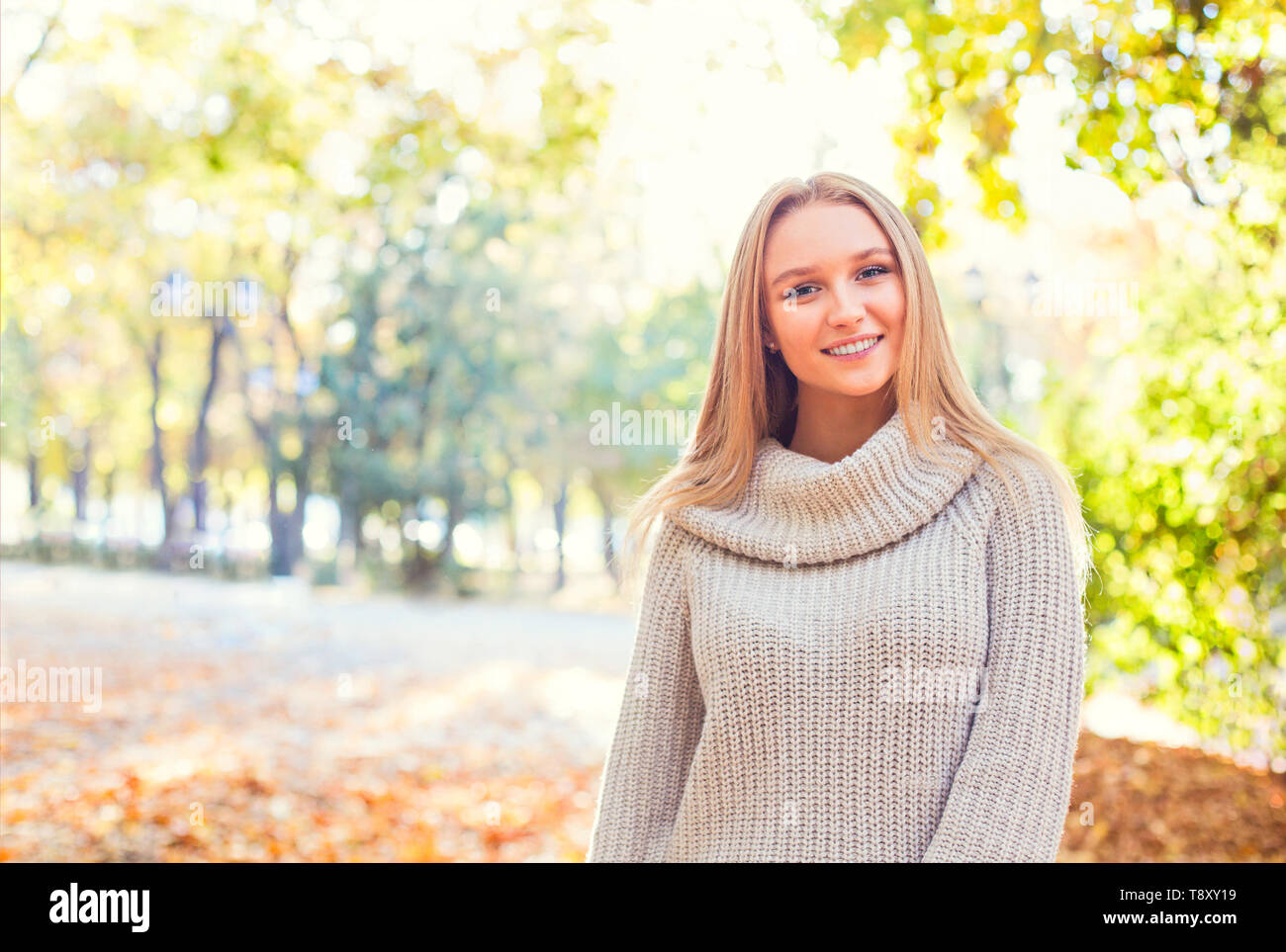 Happy blond girl posing in autumn park on yellow trees background Stock ...