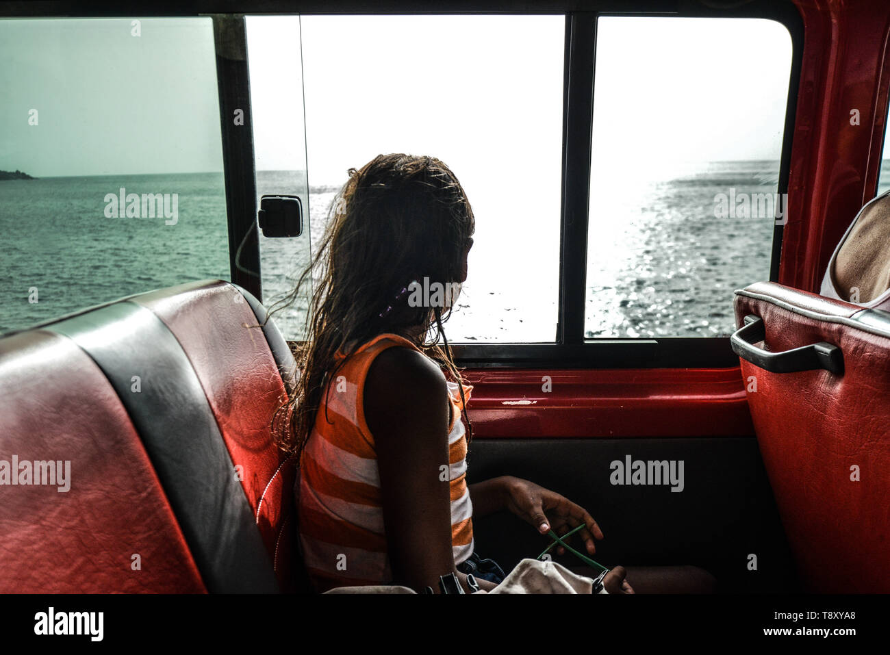 Cape Verde, Cabo Verde archipelago, Brava Island: little girl in a collectivo or aluguer, a private minibus (taxi) criss-crossing the island, looking  Stock Photo