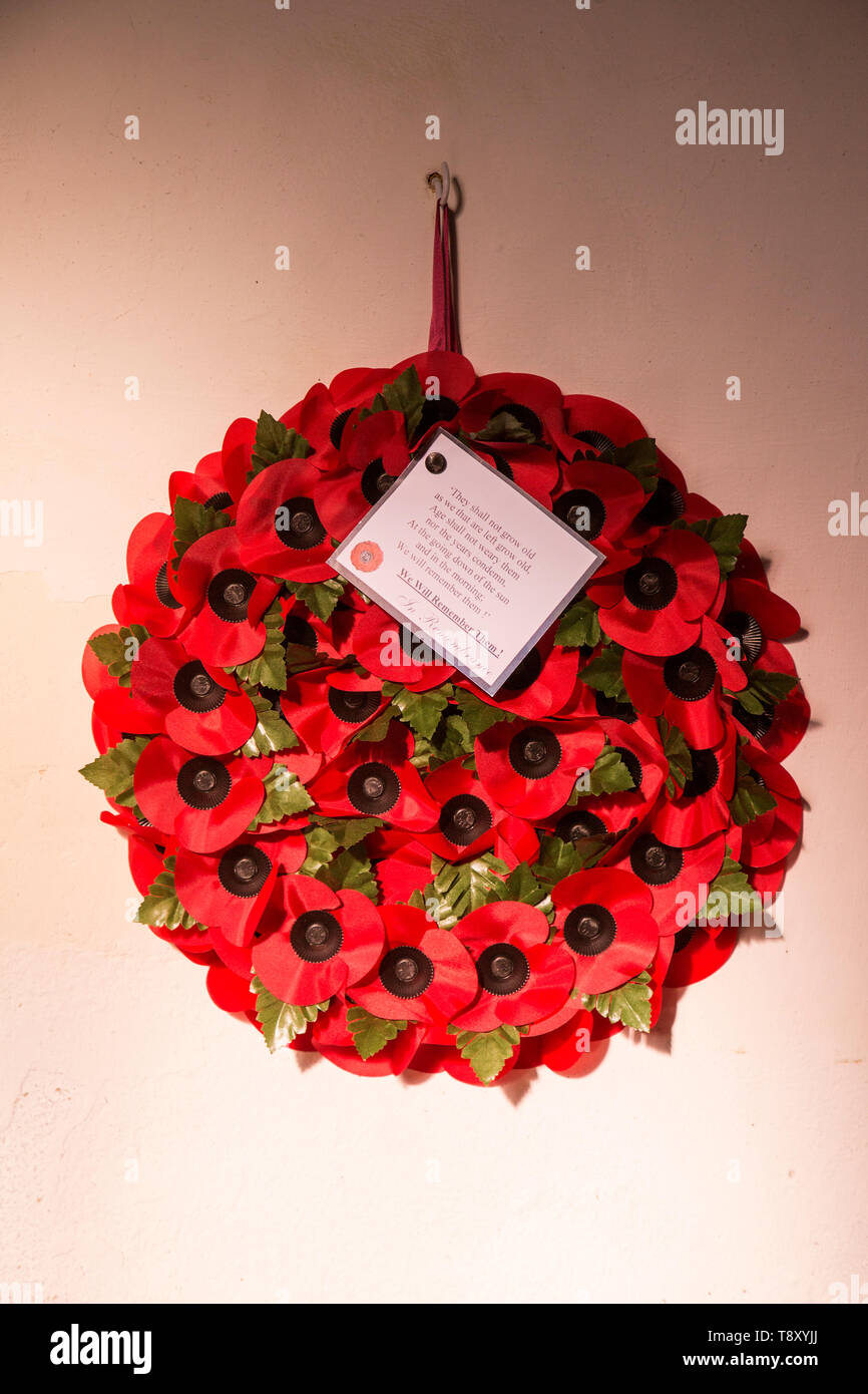 'We will remember them' remembrance day poppy wreath hanging from wall inside the church at South Cove, Suffolk England, UK Stock Photo
