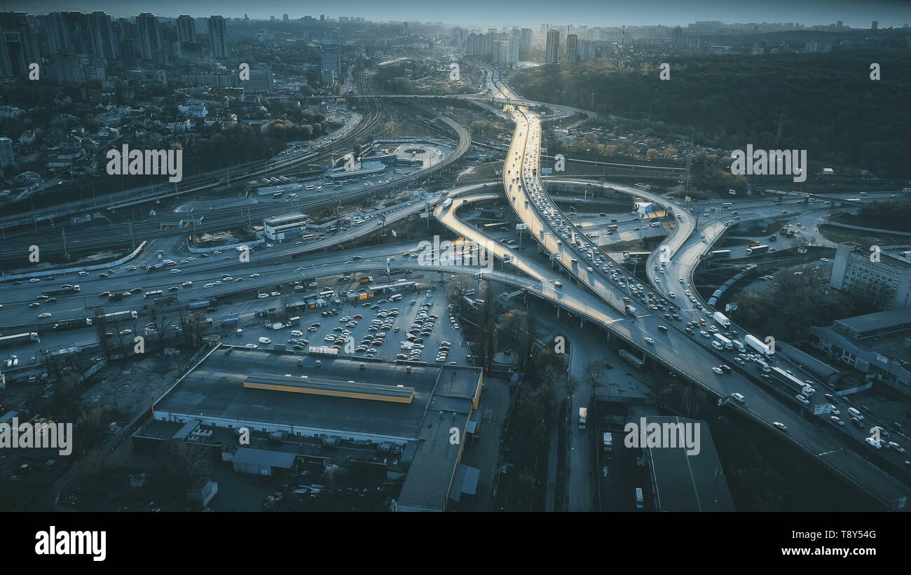 Night Aerial Urban Traffic Road System. Busy Downtown Route Development City Highway Junction Overview. Cityscape Car Motion Transport. Dark Blue Cinematic Filter. Concept Drone Flight Shot Stock Photo