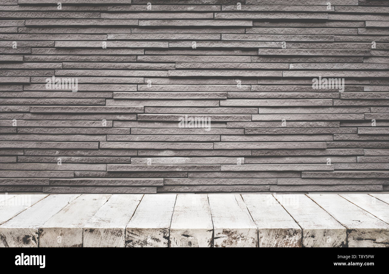 Empty wood table top with brick wall background. Stock Photo