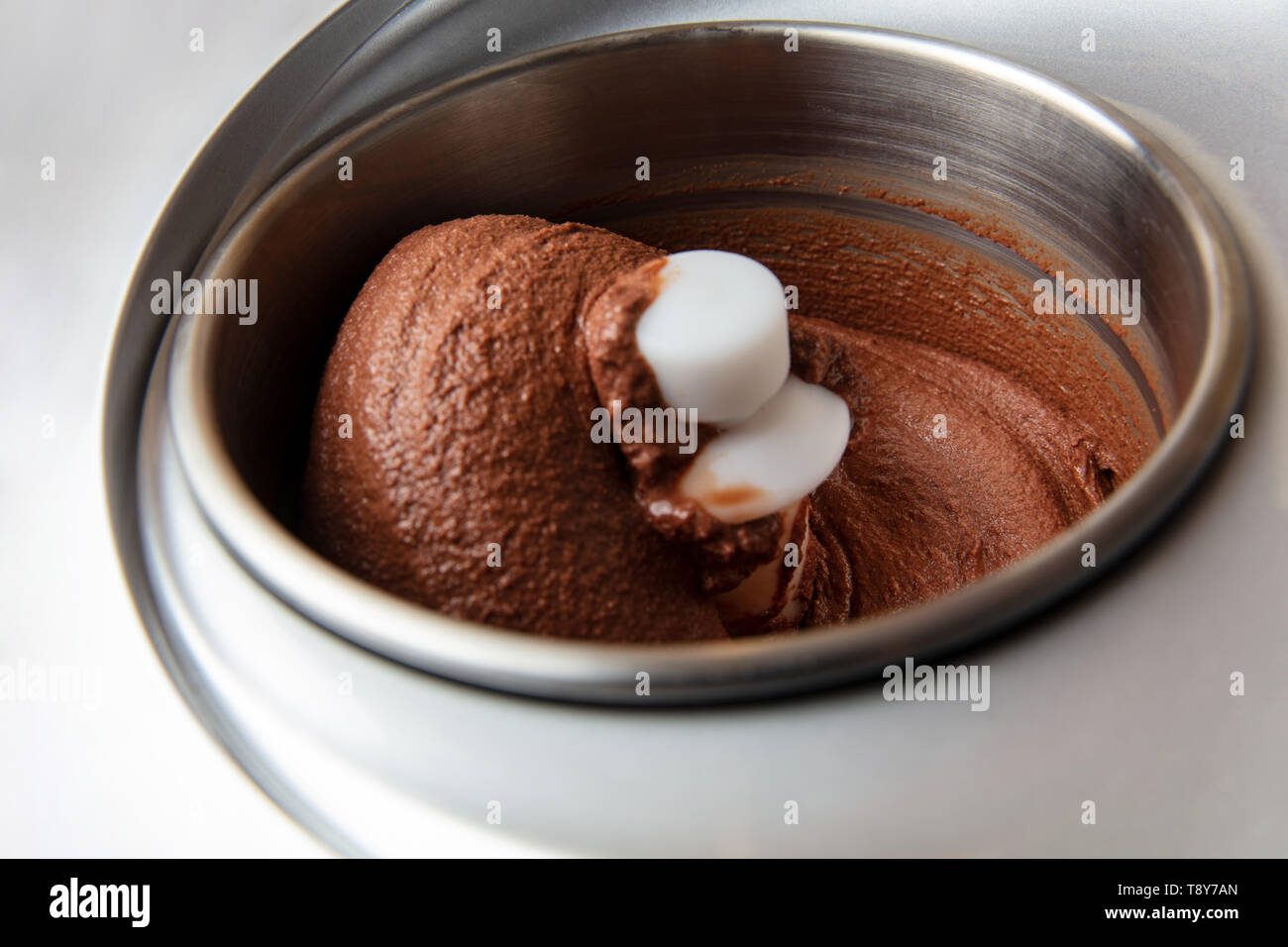 Ice cream maker stirs when making homemade chocolate ice cream Stock Photo