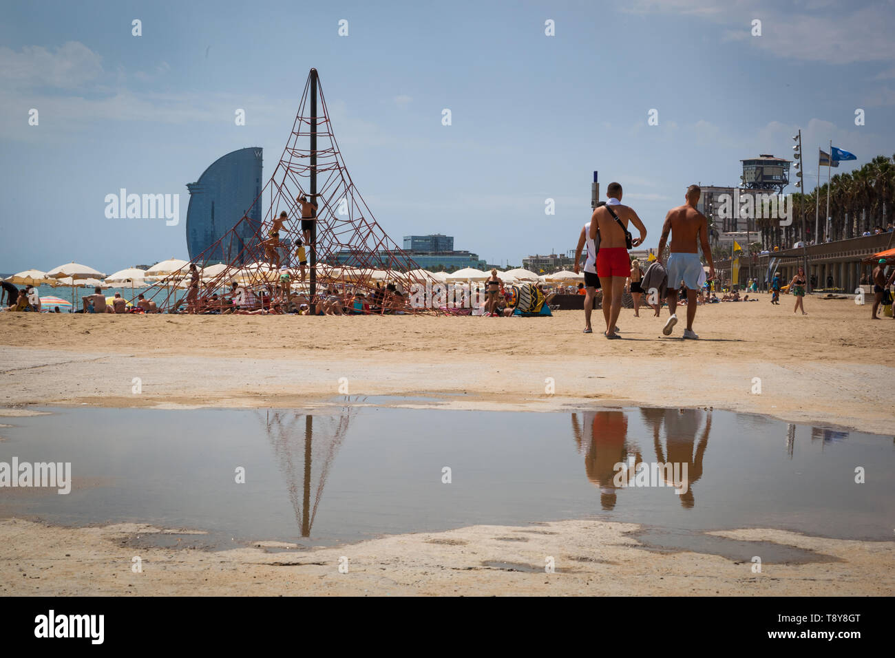 Beach After Rian Barcelona beach after rain with big puddle, climbing frame and modern ...