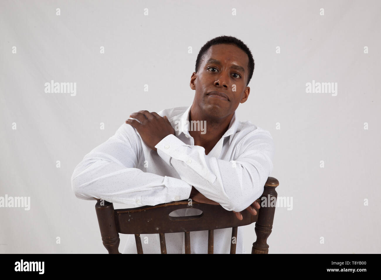 Handsome black man sitting backwards in a chair Stock Photo Alamy