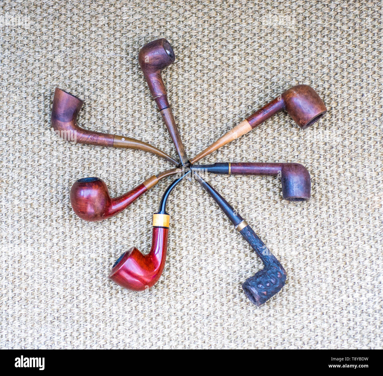 Different tobacco smoking pipes laid on a mesh background Stock Photo