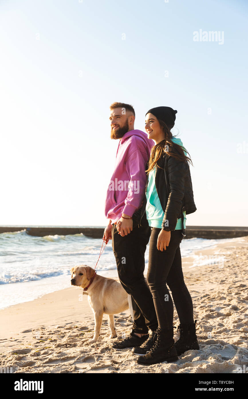 Lovely young couple walking with their dog at the beach Stock Photo - Alamy
