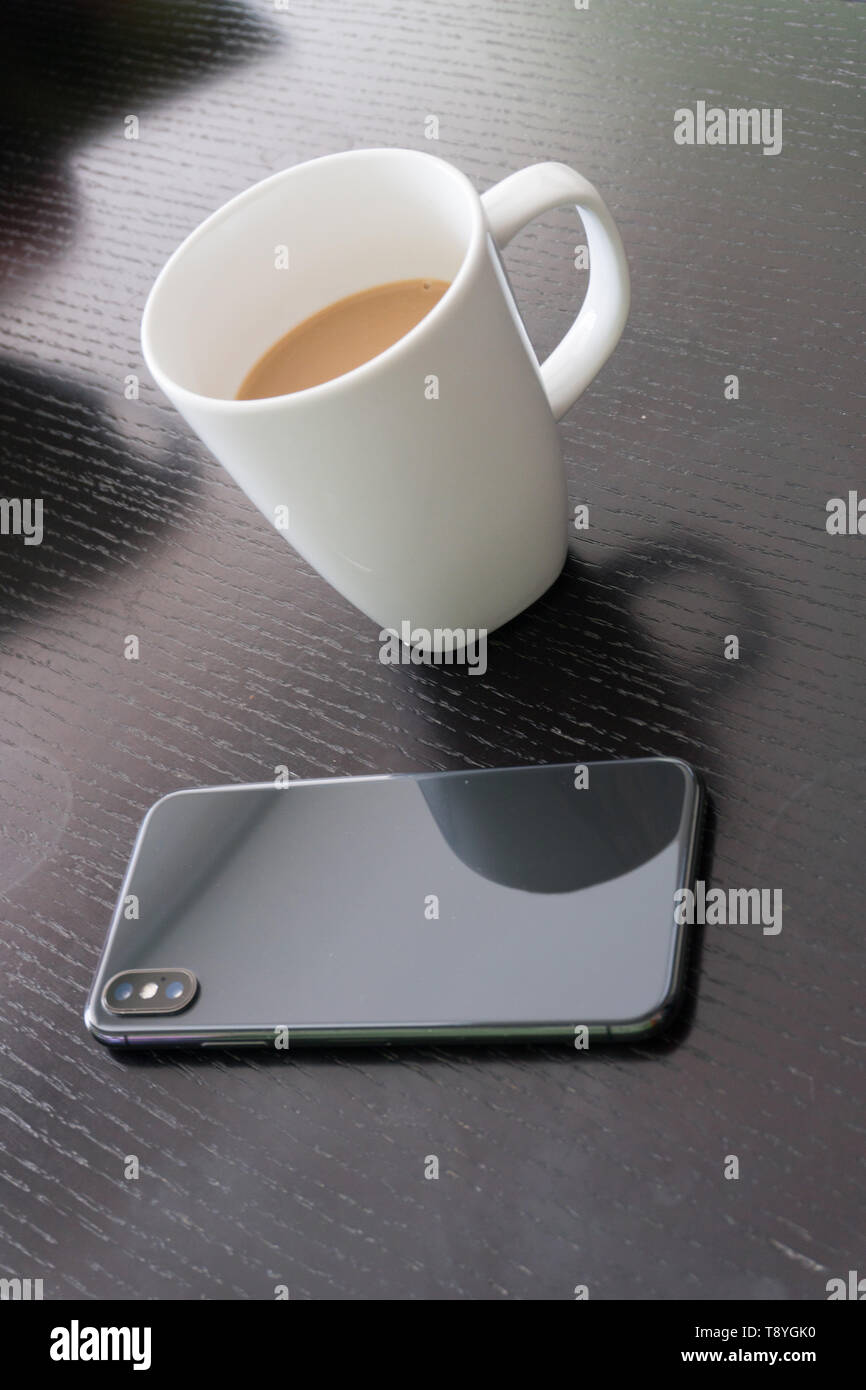 cup of coffee and business mobile phone on black wood table Stock Photo