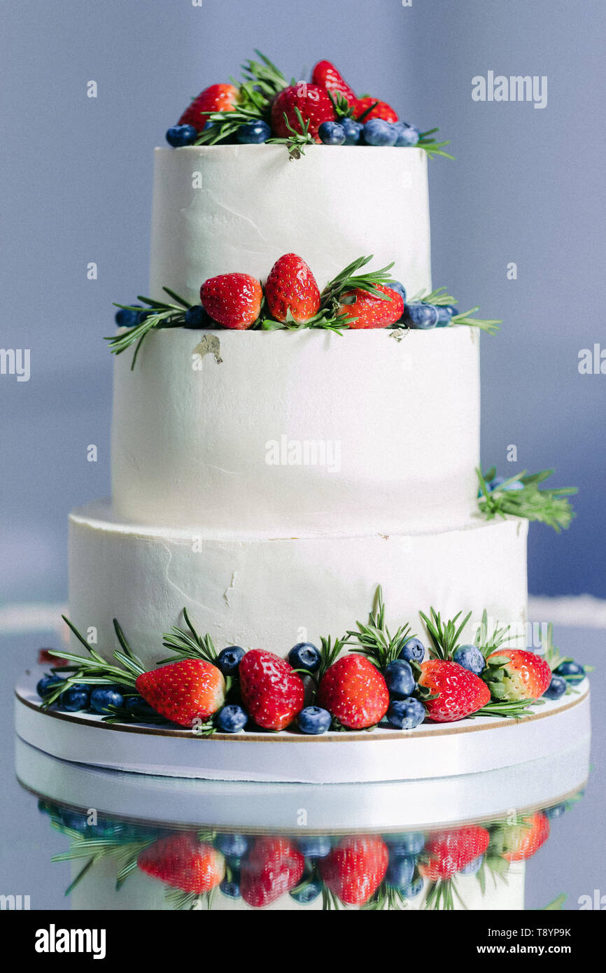 White wedding cake with fruit, strawberry and blueberries Stock Photo