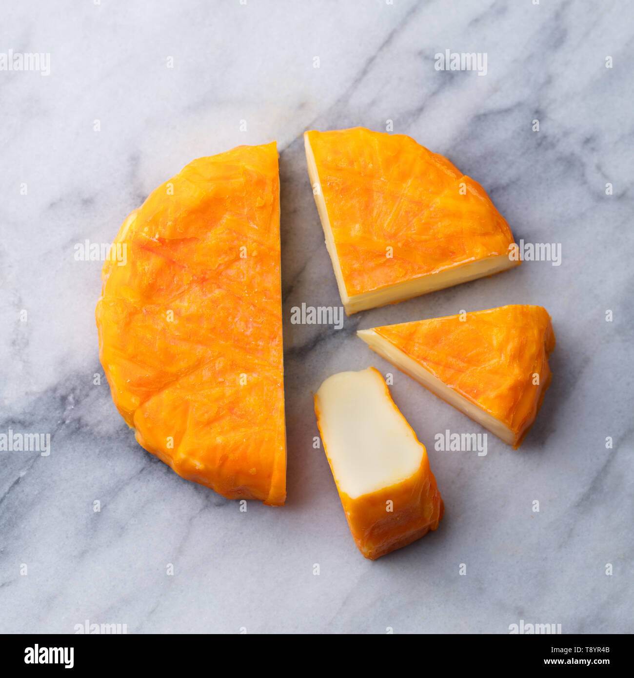 Cheese with washed orange rind. French or German. Marble table background. Top view Stock Photo