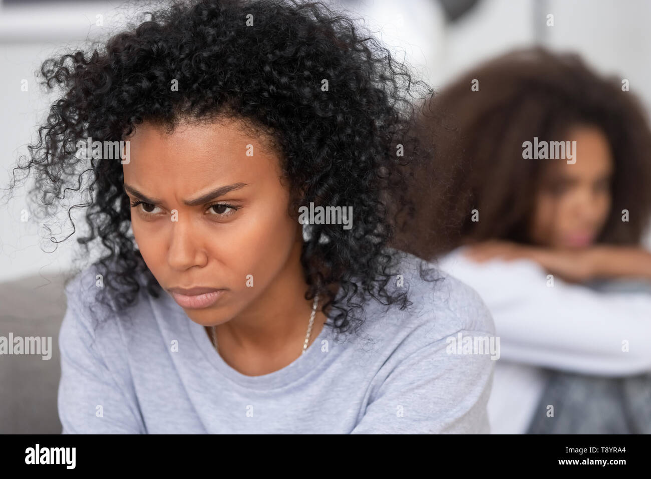 Upset angry African American mother ignoring daughter after quarrel Stock Photo
