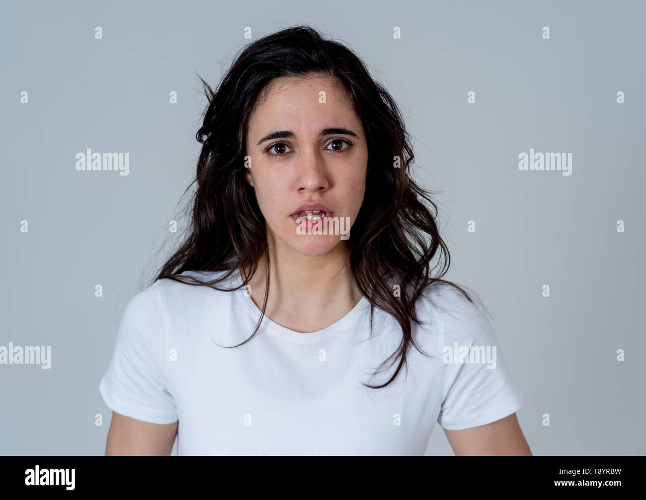 Young latin woman feeling disgust looking at something unpleasant making fear, anxiety gestures trying to cover herself in shock. Portrait with copy s Stock Photo