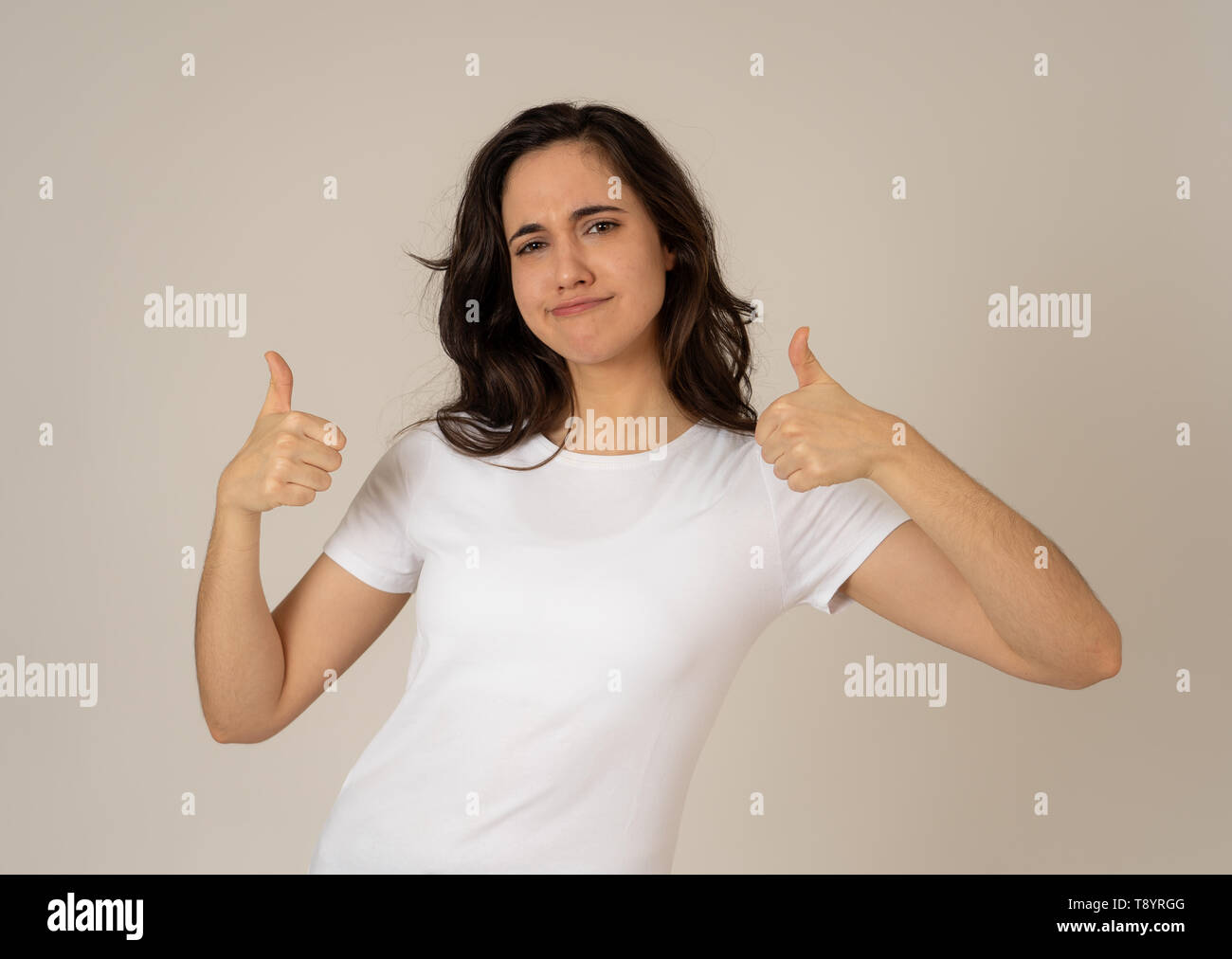 Portrait of beautiful young latin woman showing thumbs up sign feeling ...