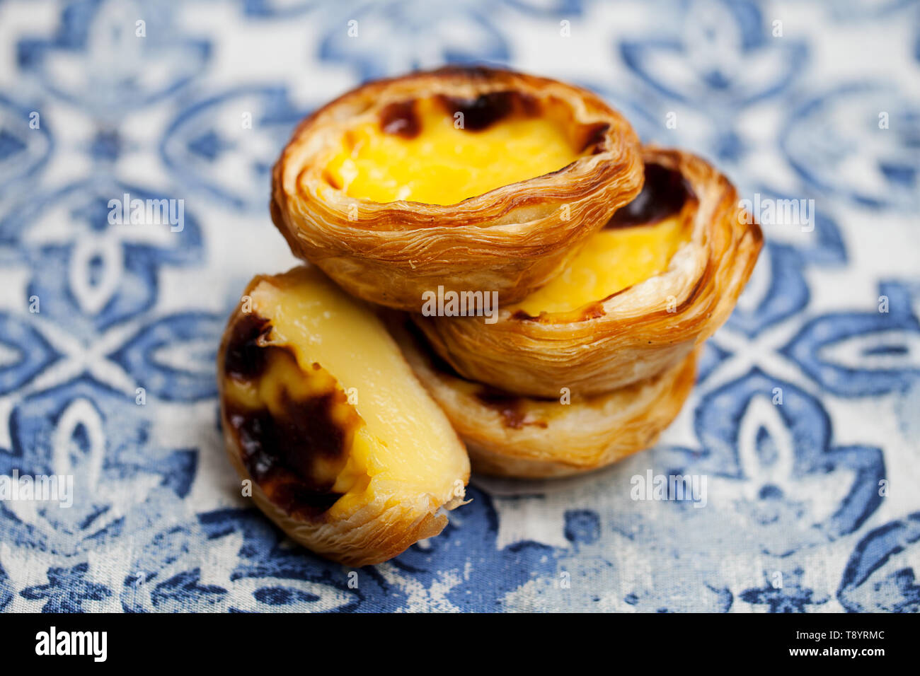 Egg tart, traditional Portuguese dessert, pastel de nata. Blue background. Close up. Stock Photo