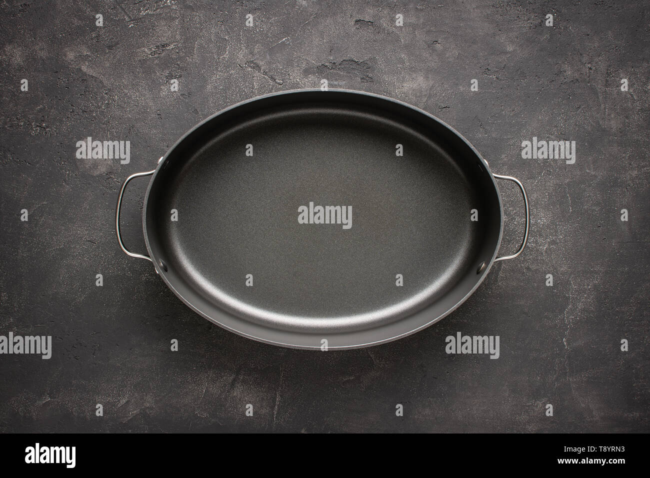 Empty Gray Nonstick Baking Dish with Handles on Dark Stone Surface. Culinary Background. Stock Photo