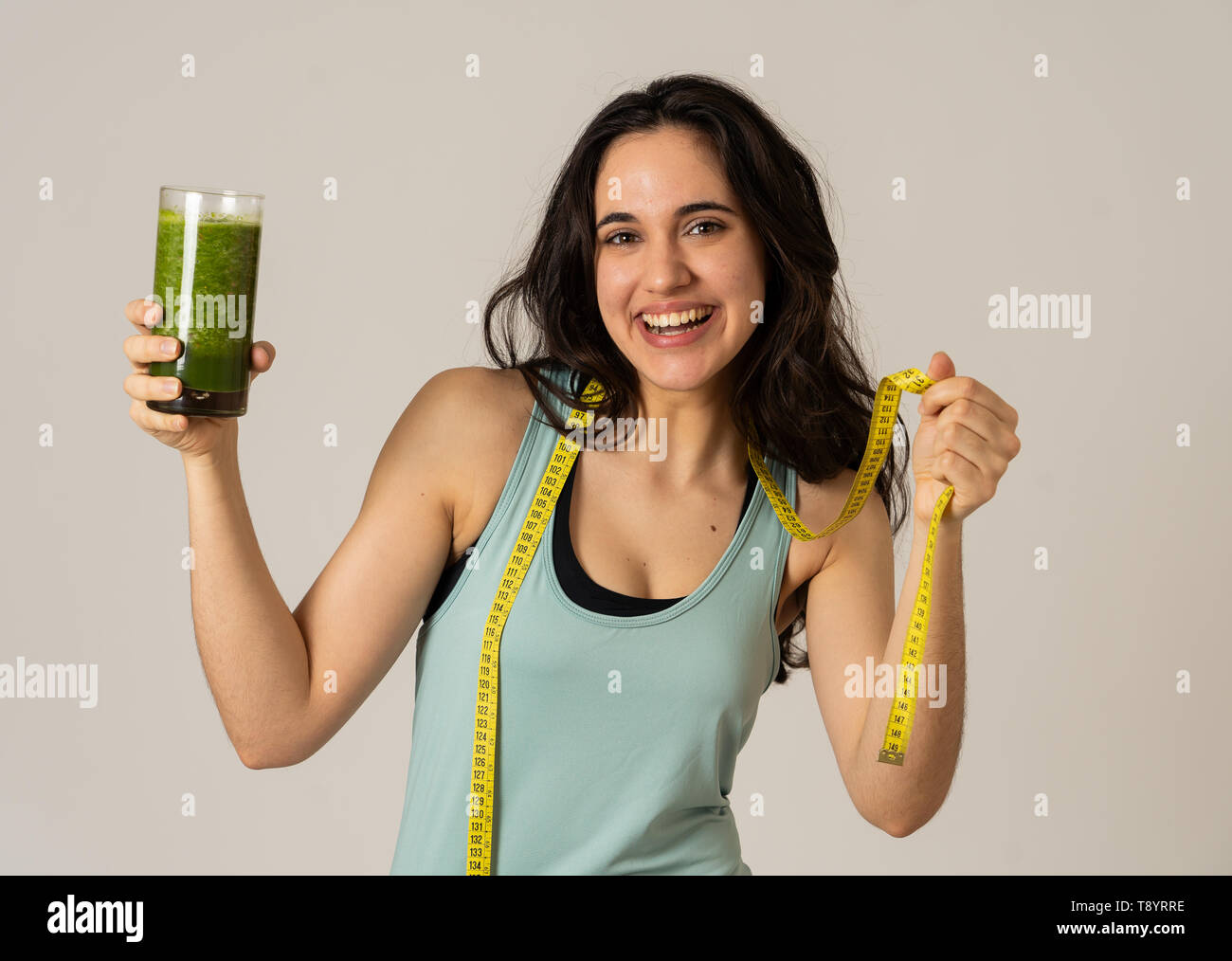 Fitness woman smiling happy with diet plan to loose weight; exercise and green vegetable smoothie healthy drink. In Beauty body care, Health Fitness D Stock Photo